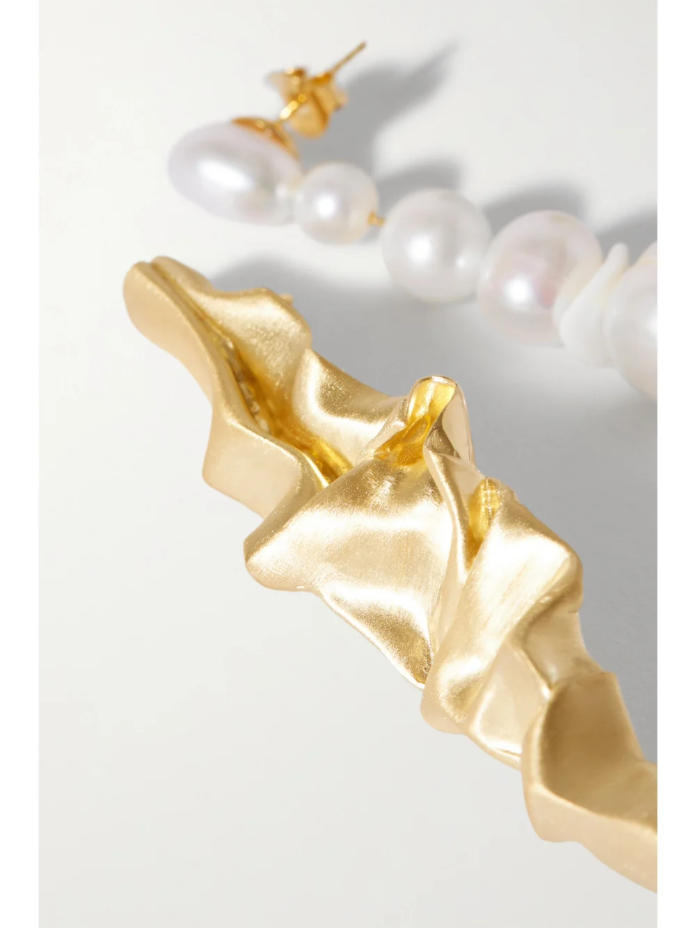 Close-up detail of the Completedworks Crumple Gold Vermeil, Pearl and Ceramic Earrings