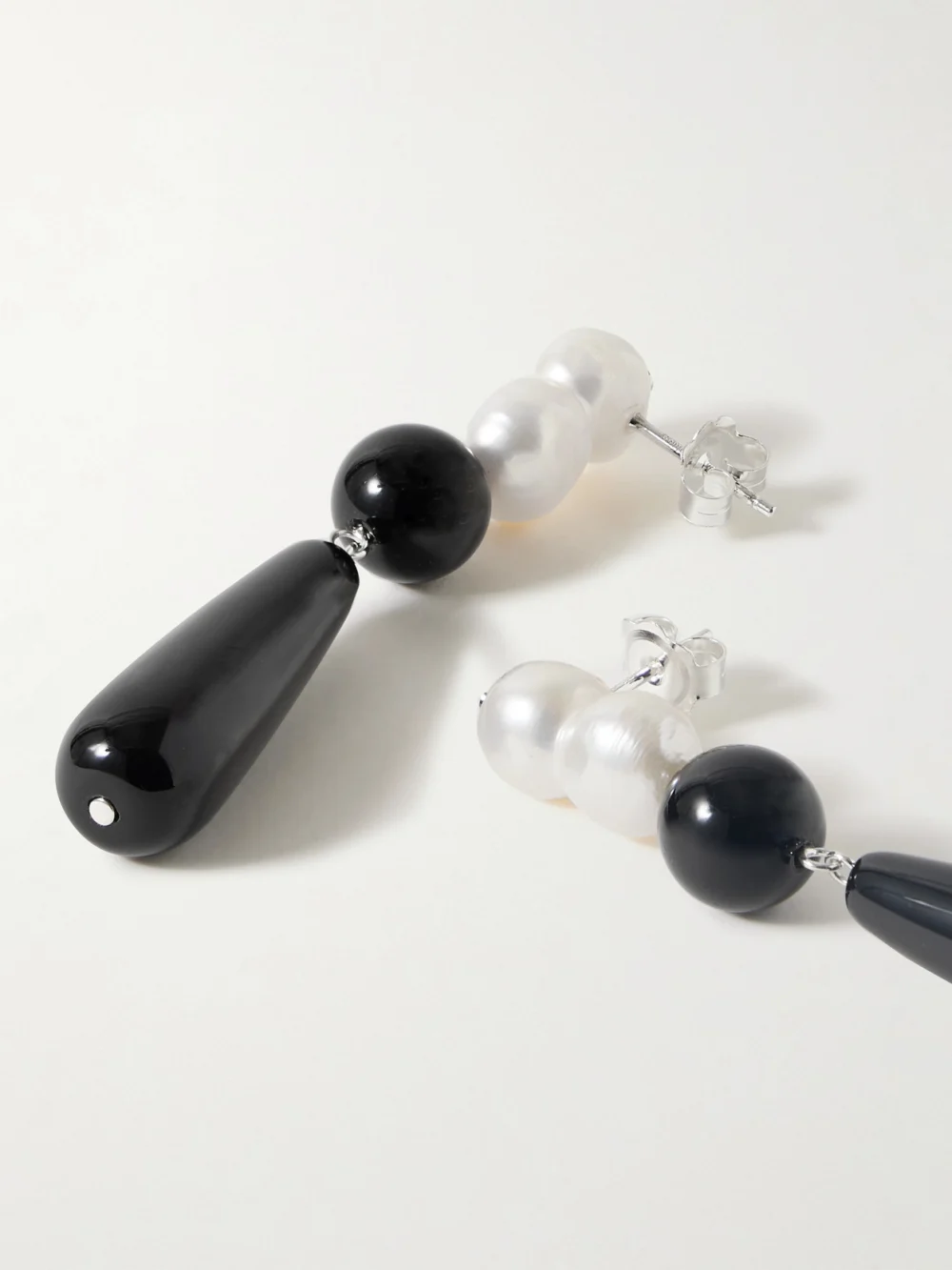 Close-up detail of the Completedworks Tarn Ii Recycled Silver, Onyx and Pearl Earrings