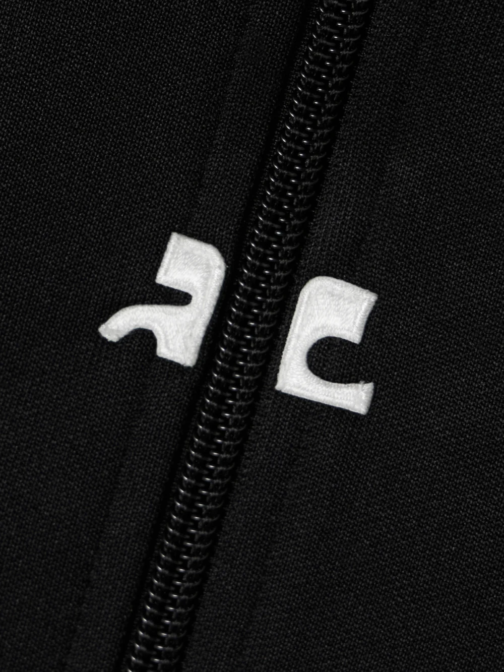 Close-up detail of the Courrèges Interlock Appliquéd Jersey Turtleneck Mini Dress