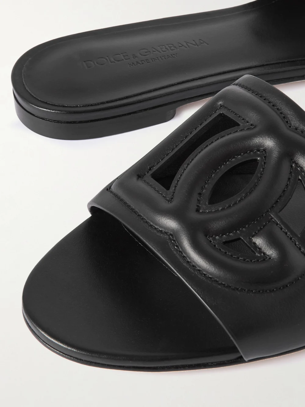 Close-up detail of the Dolce & Gabbana Bianca Logo-embossed Cutout Leather Slides