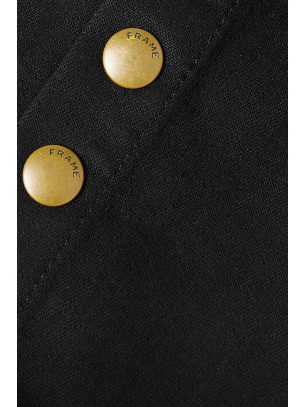 Close-up detail of the Frame The Snapped Denim Leggings