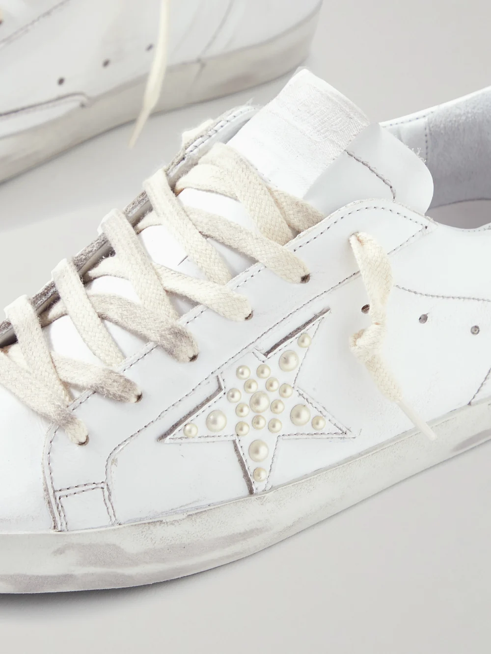 Close-up detail of the Golden Goose Superstar Faux Pearl-embellished Distressed Leather Sneakers