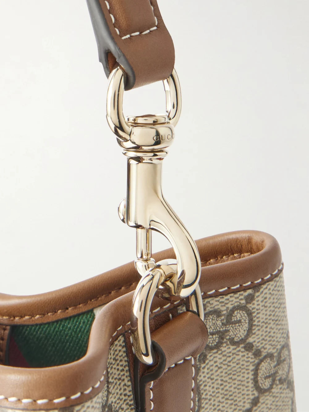 Close-up detail of the Gucci Gg Emblem Leather-trimmed Coated Canvas-jacquard Top-handle Bag