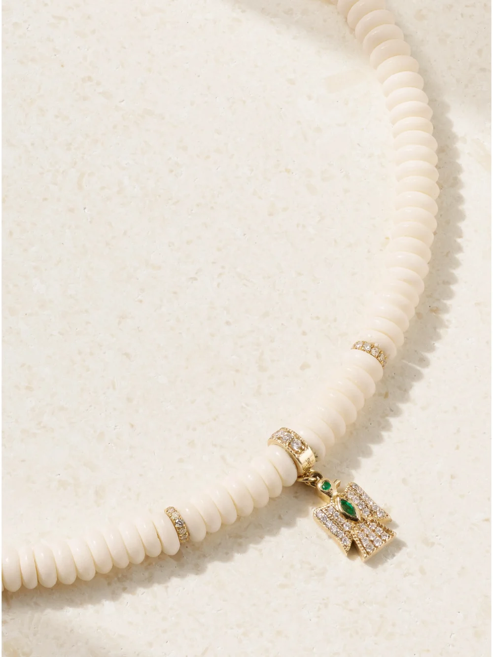 Close-up detail of the Jacquie Aiche Thunderbird 14-karat Gold, Bone, Diamond and Emerald Necklace
