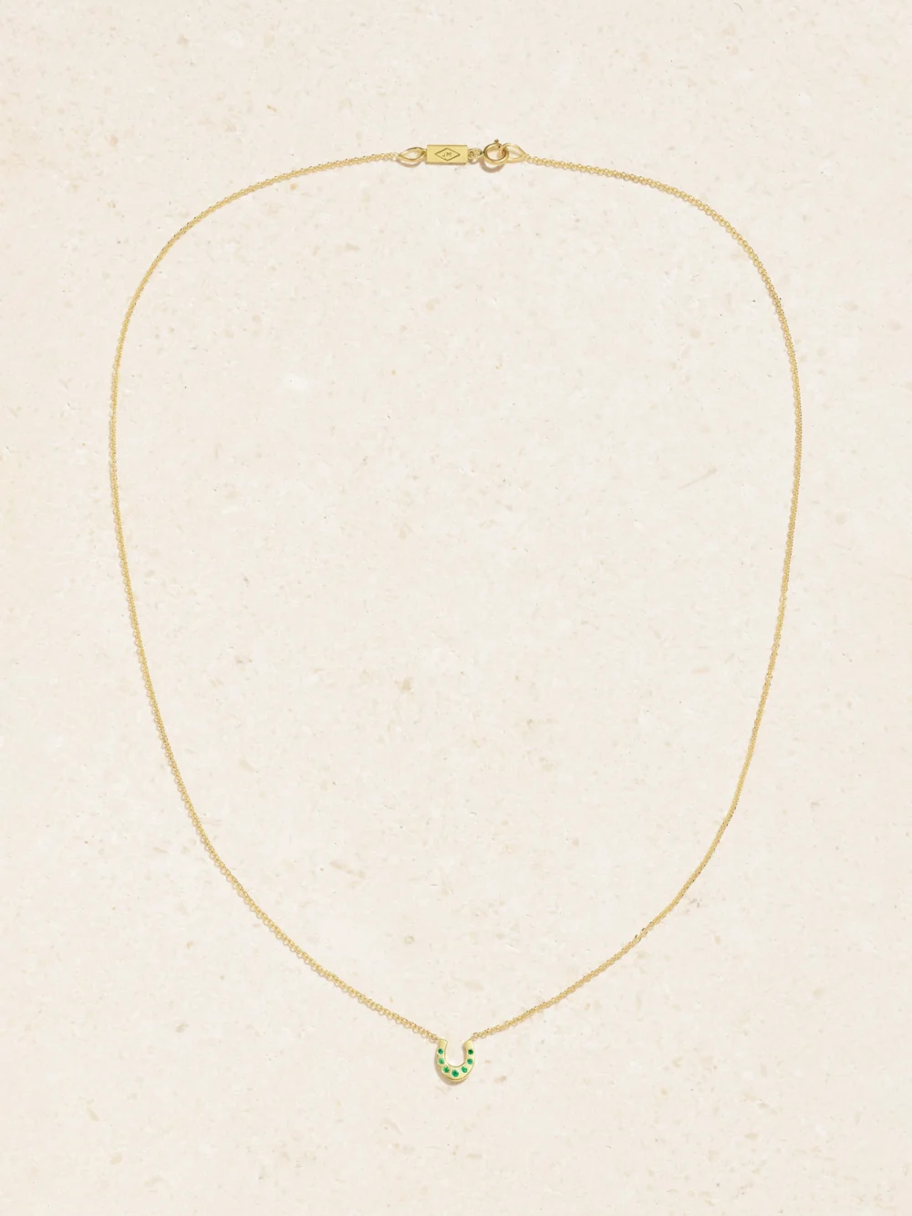 Close-up detail of the Jennifer Meyer Mini Horseshoe 18-karat Gold Emerald Necklace