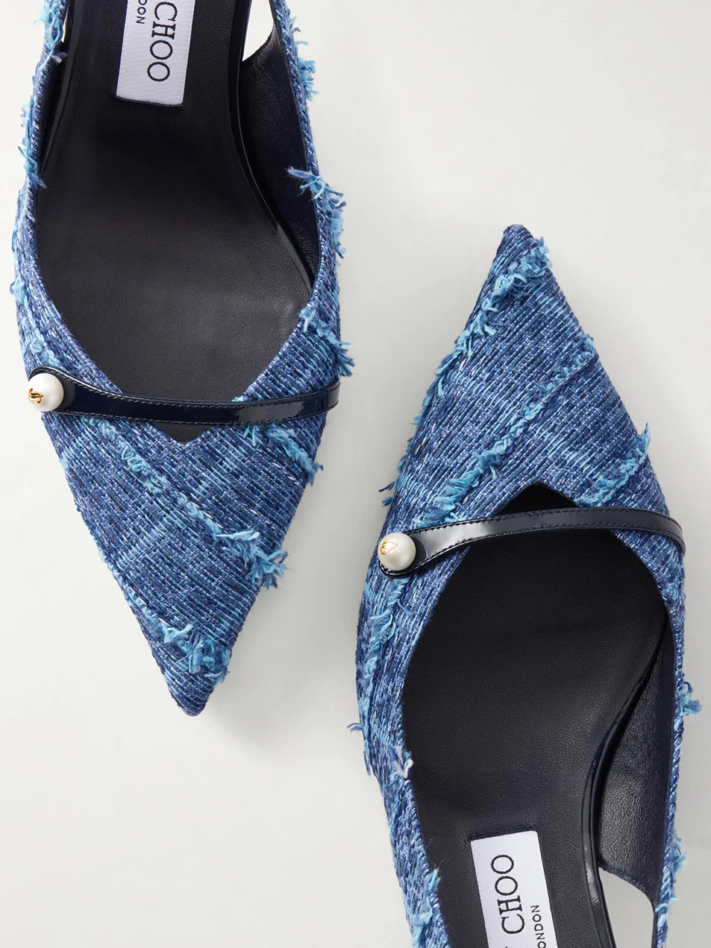 Close-up detail of the Jimmy Choo Amita 45 Leather-trimmed Frayed Denim Slingback Pumps