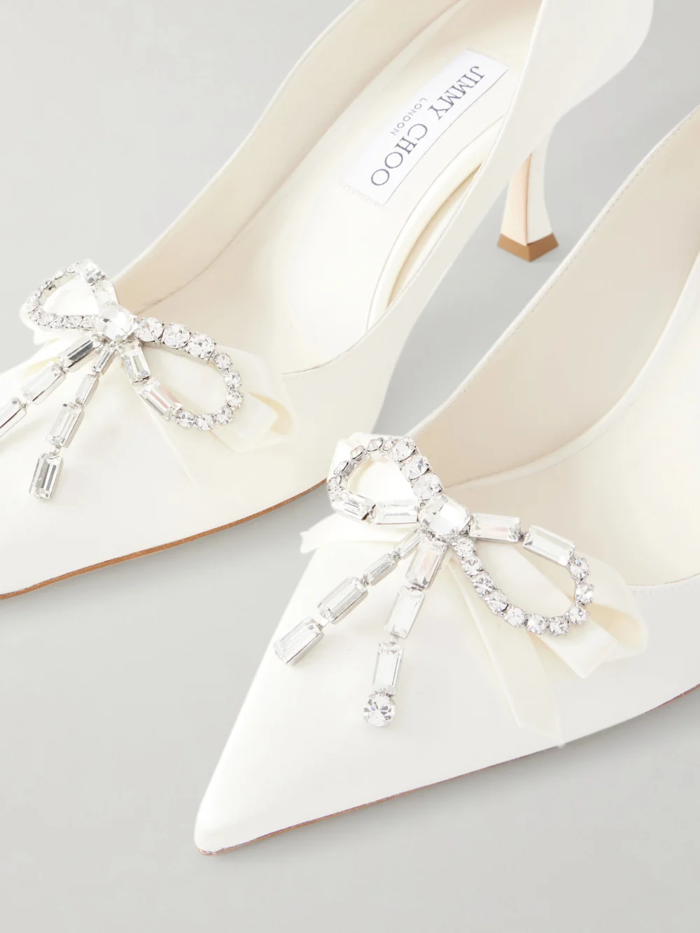 Close-up detail of the Jimmy Choo Aura 70 Crystal Bow-embellished Satin Pumps