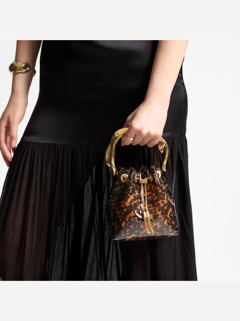 Side view of the Jimmy Choo Bon Bon Transparent Tortoiseshell Bucket Bag with Sculpted Handle