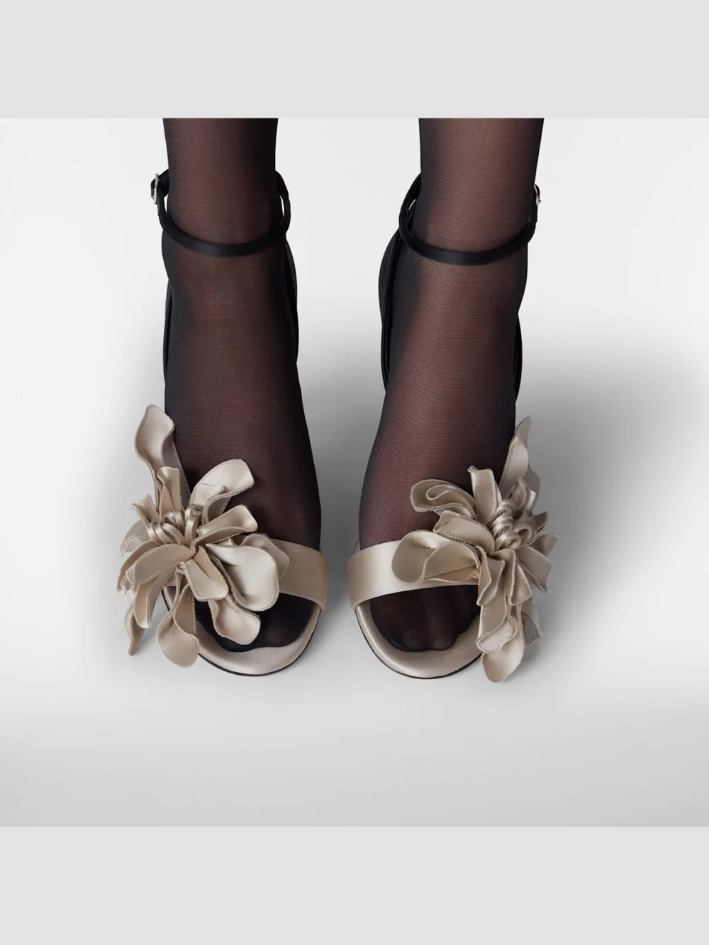 Close-up detail of the Jimmy Choo Coko 100 Bone and Black Satin Sandals with Floral Accent