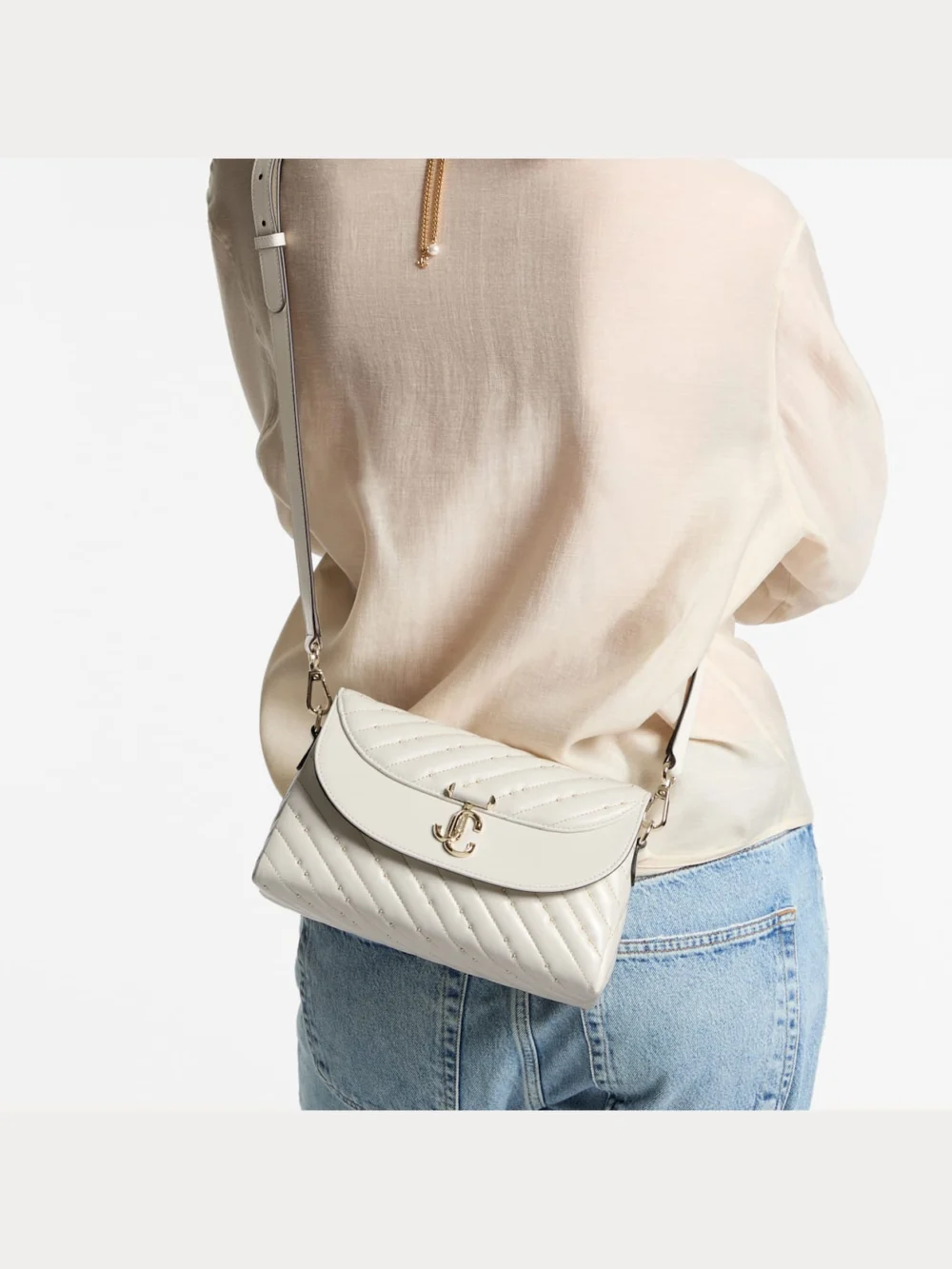 Side view of the Jimmy Choo Curve Top Handle Latte Quilted Nappa Leather Top Handle Bag with Pearl Detail