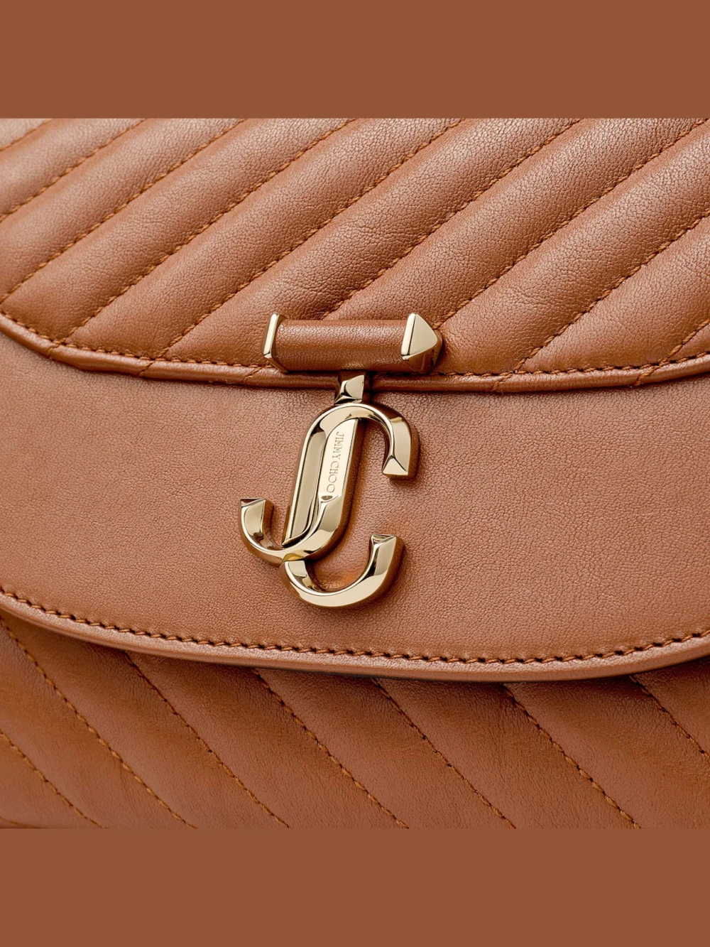 Close-up detail of the Jimmy Choo Curve Top Handle Tan Quilted Biker Leather Top Handle Bag with Pearl Detail