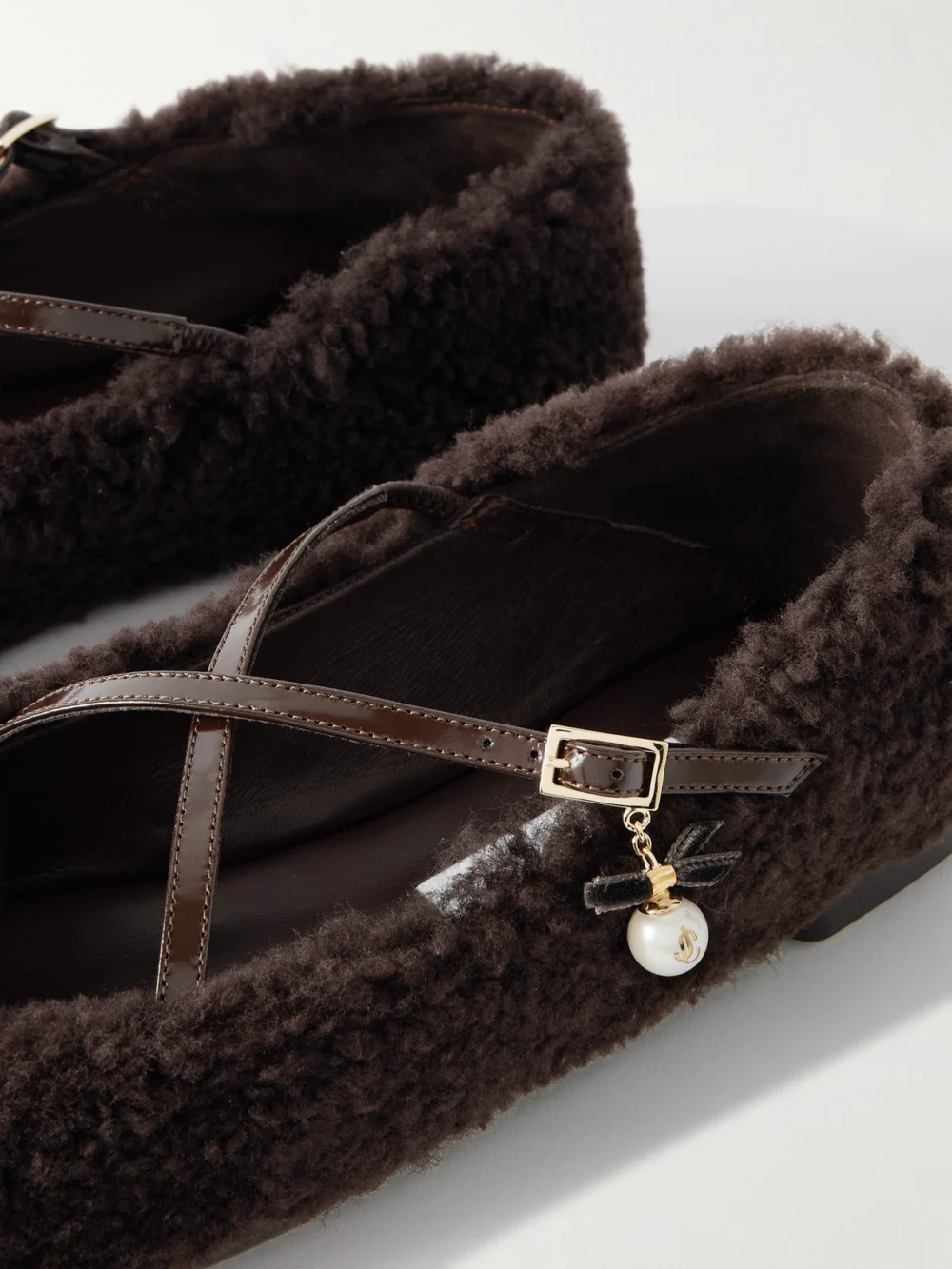 Close-up detail of the Jimmy Choo Eleri Embellished Patent Leather-trimmed Shearling Ballet Flats