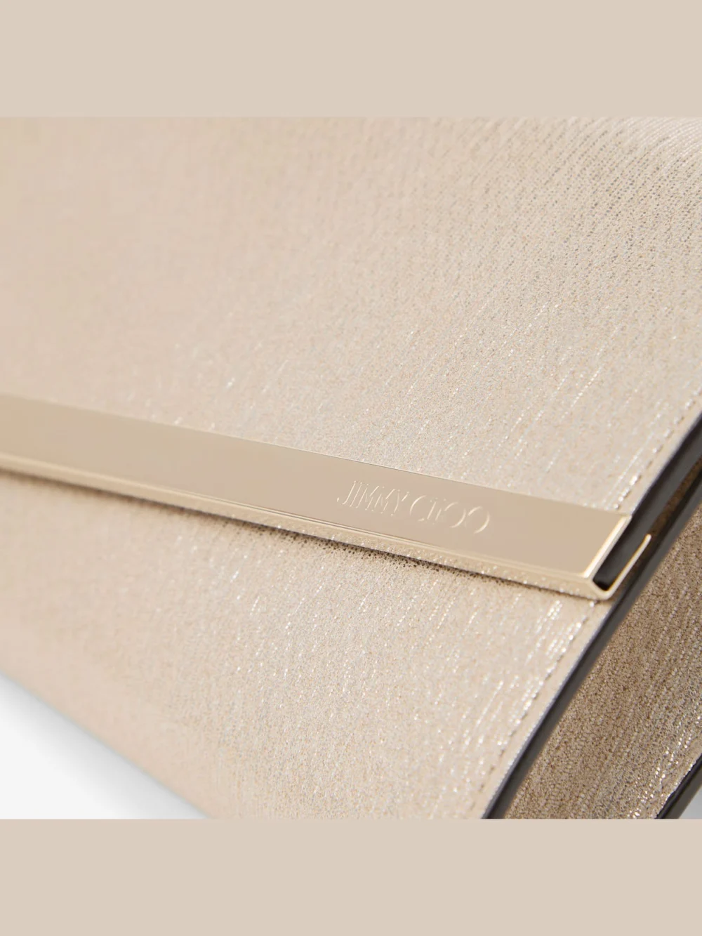 Close-up detail of the Jimmy Choo Emmie Soft Gold Metallic Linear Leather Clutch