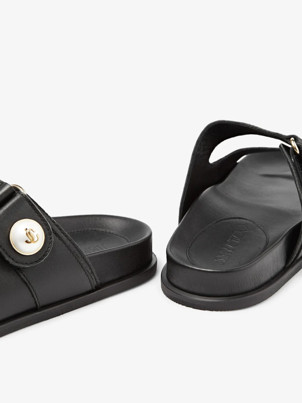 Close-up detail of the Jimmy Choo Fayence Sandal Black Leather Flat Sandals with Pearl Embellishment