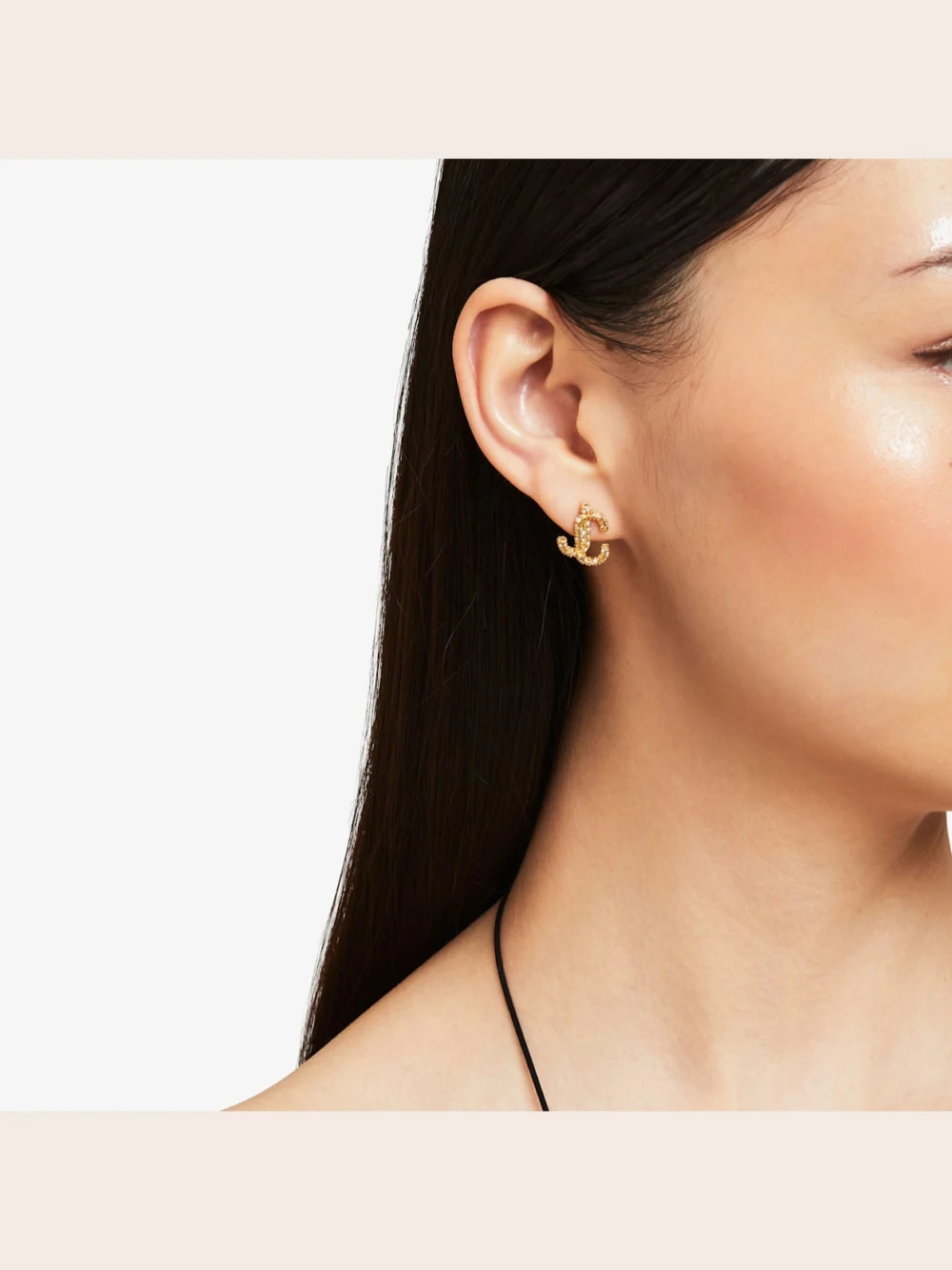 Close-up detail of the Jimmy Choo Jc Studs Gold Finish Metal Jc Stud Earrings with Swarovski Crystals