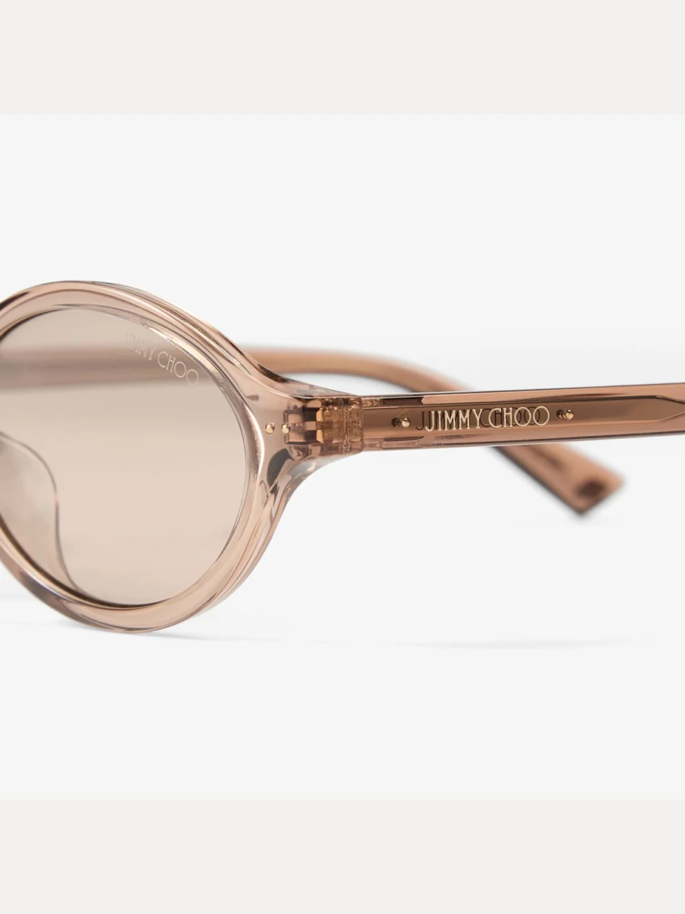 Close-up detail of the Jimmy Choo Marais Transparent Tan and Light Brown Oval Acetate Sunglasses