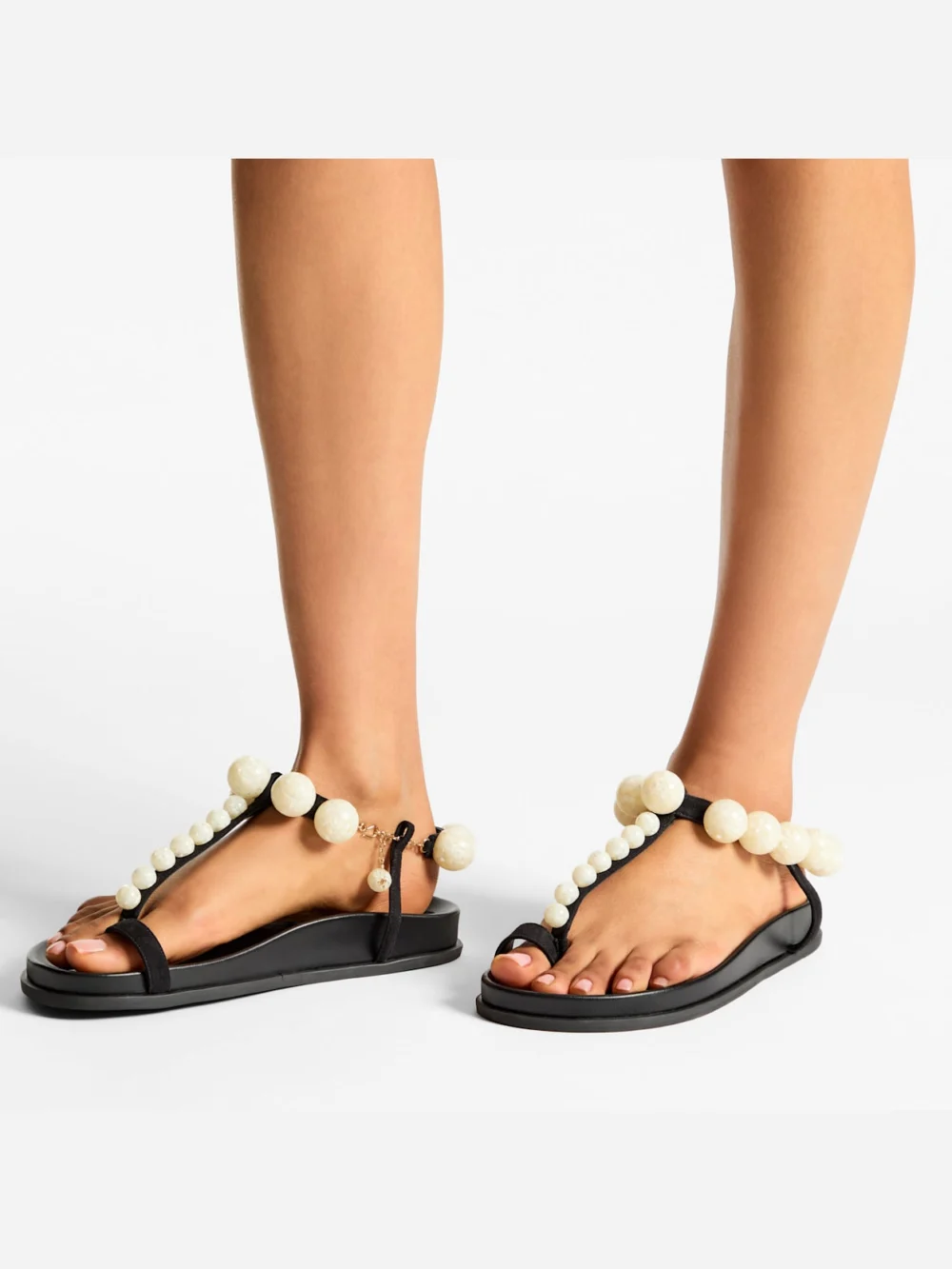 Side view of the Jimmy Choo Miro Flat Black Suede Sandals with Mother of Pearl Spheres