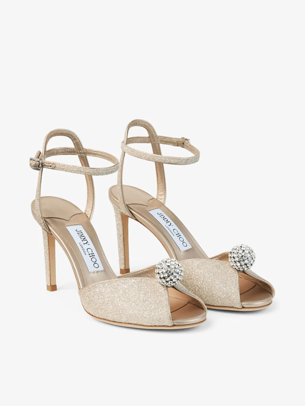 Close-up detail of the Jimmy Choo Sacora 85 Light Soft Gold Glitter Fabric Sandals with Crystal Sphere