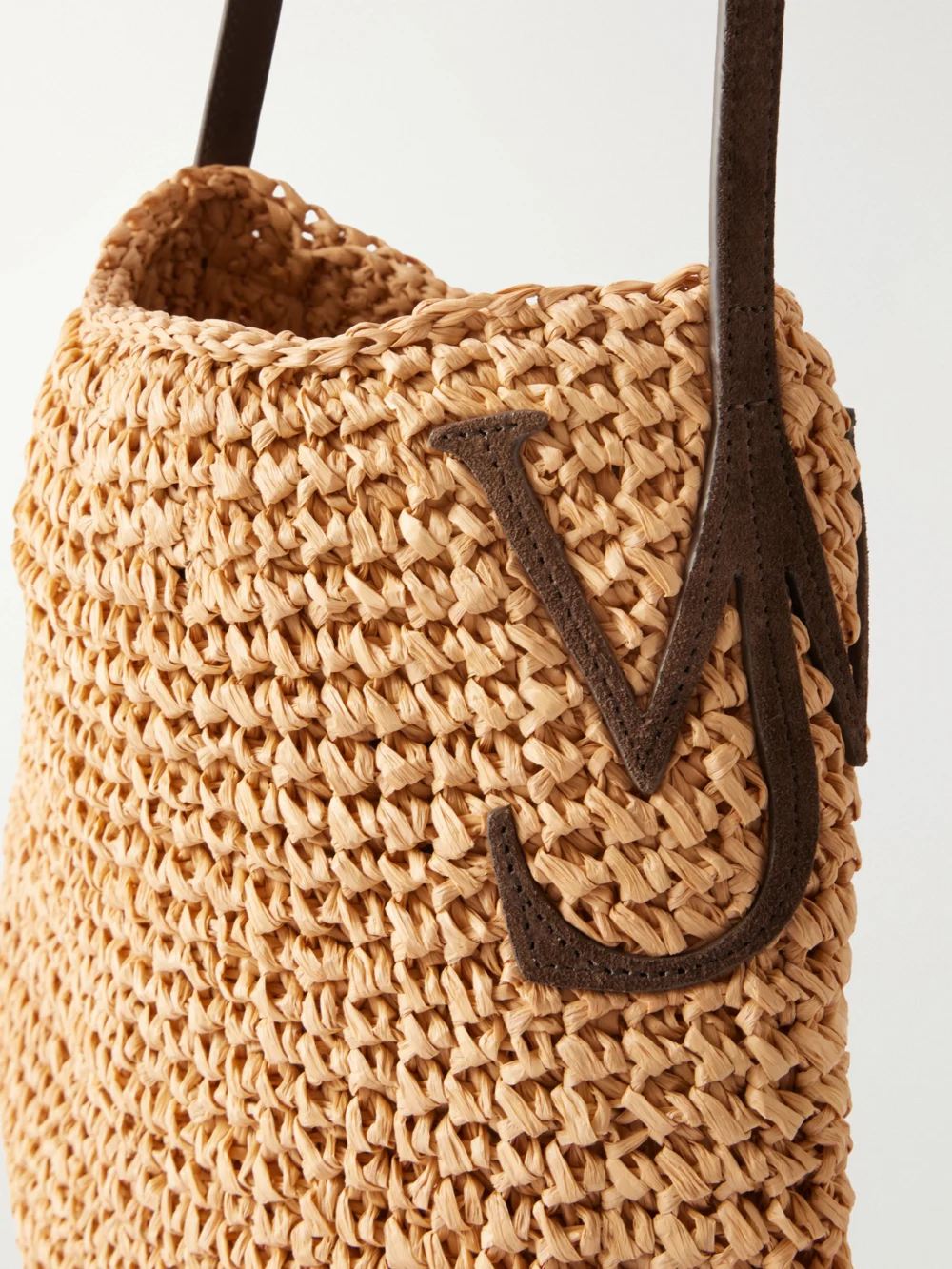 Close-up detail of the JW Anderson Bulb Leather-trimmed Raffia Shoulder Bag