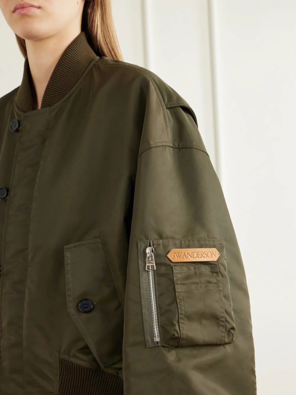 Close-up detail of the JW Anderson Oversized Tipped Hem Rib-trimmed Satin Bomber Jacket