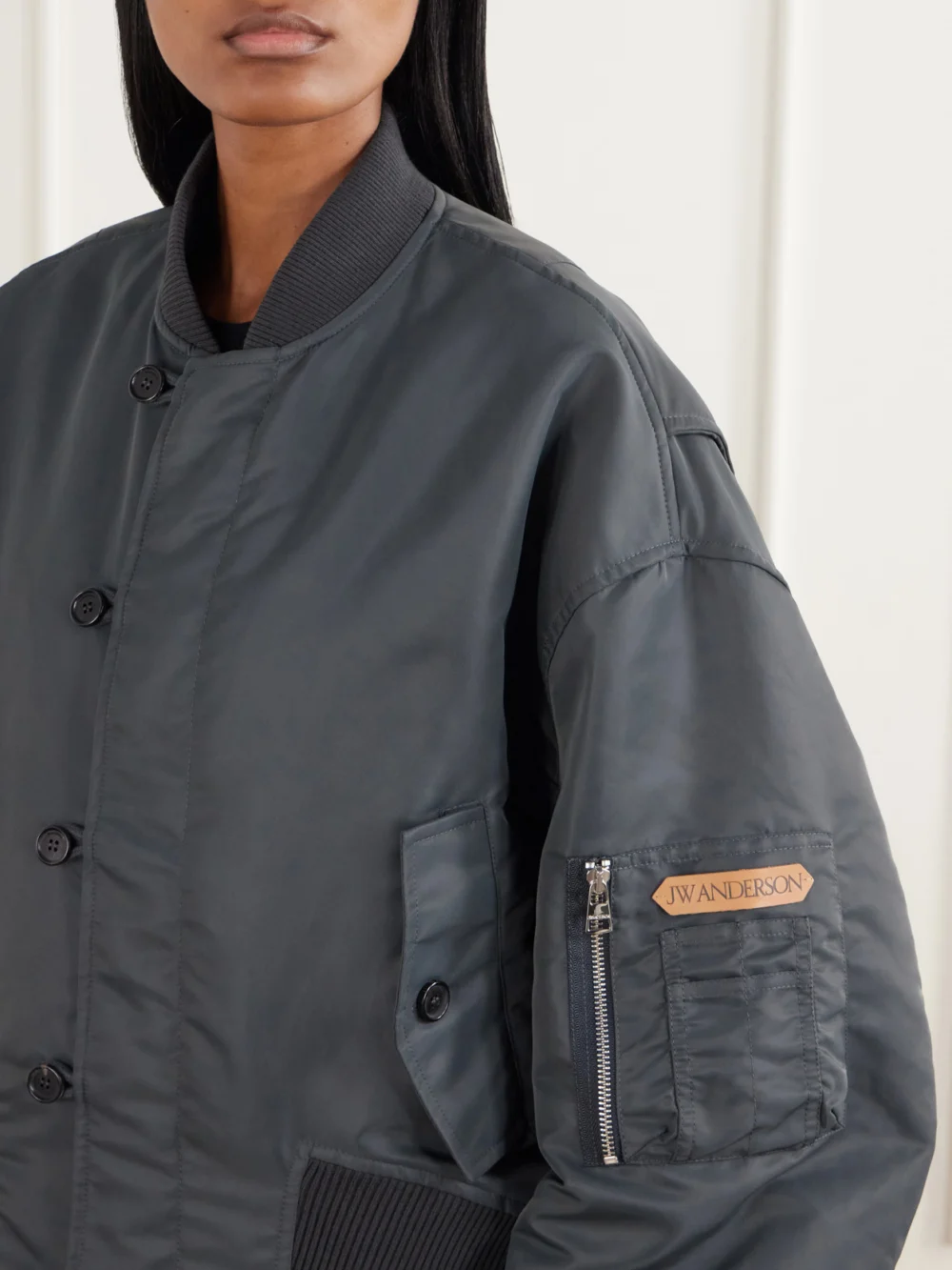 Close-up detail of the JW Anderson Oversized Tipped Hem Rib-trimmed Satin Bomber Jacket
