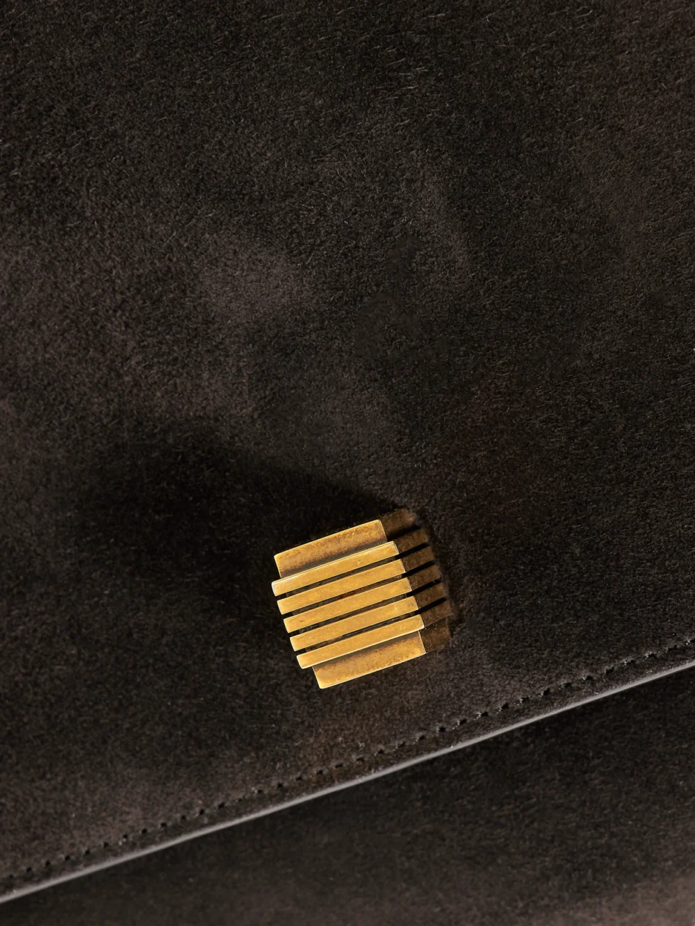Close-up detail of the Khaite Audrey Suede Clutch