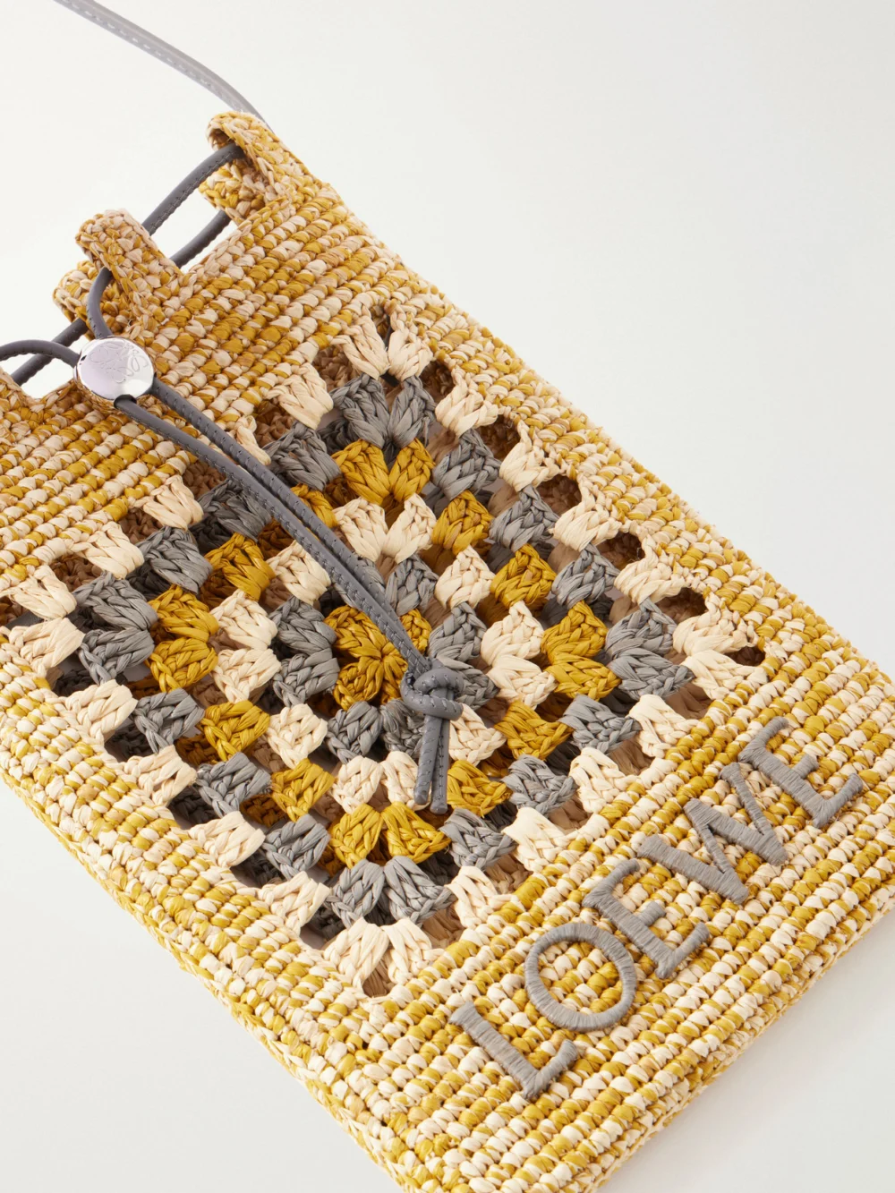 Close-up detail of the Loewe + Paula's Ibiza Leather-trimmed Crocheted Raffia Bucket Bag