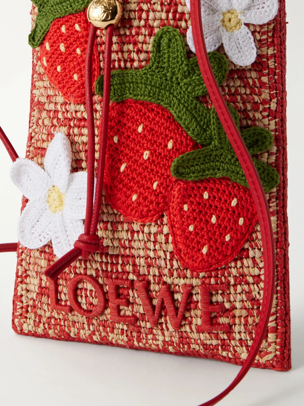 Close-up detail of the Loewe + Paula's Ibiza Leather-trimmed Embroidered Woven Raffia Bucket Bag