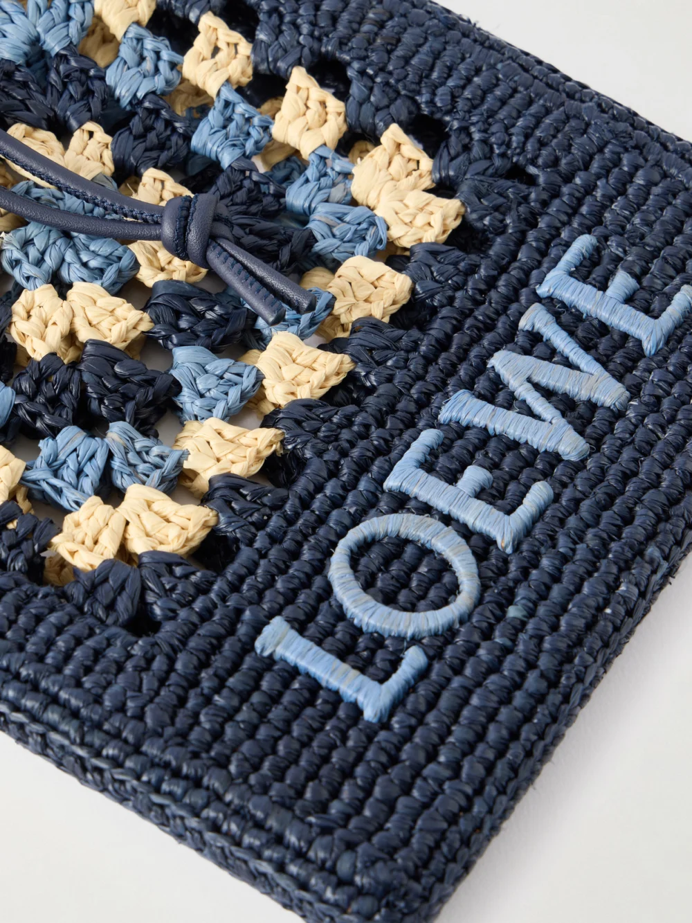 Close-up detail of the Loewe + Paula's Ibiza Logo-embroidered Leather-trimmed Crocheted Raffia Bucket Bag