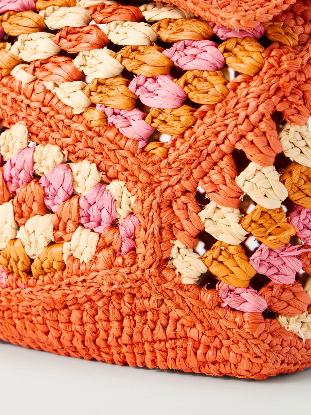 Close-up detail of the Loewe + Paula's Ibiza Puzzle Edge Mini Leather-trimmed Crocheted Raffia Shoulder Bag