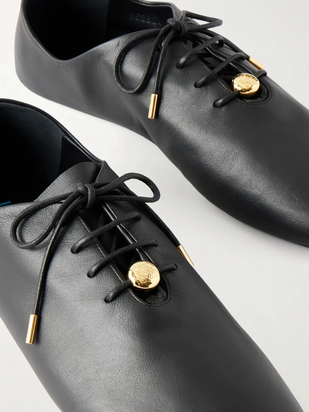 Close-up detail of the Loewe Pebble Embellished Leather Sneakers