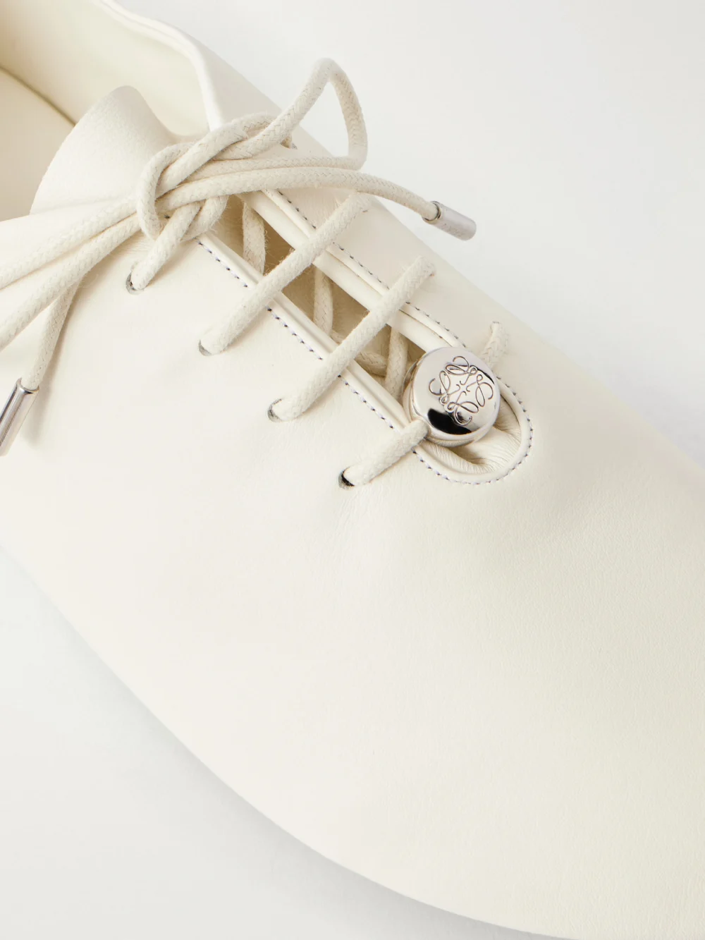 Close-up detail of the Loewe Pebble Embellished Leather Sneakers