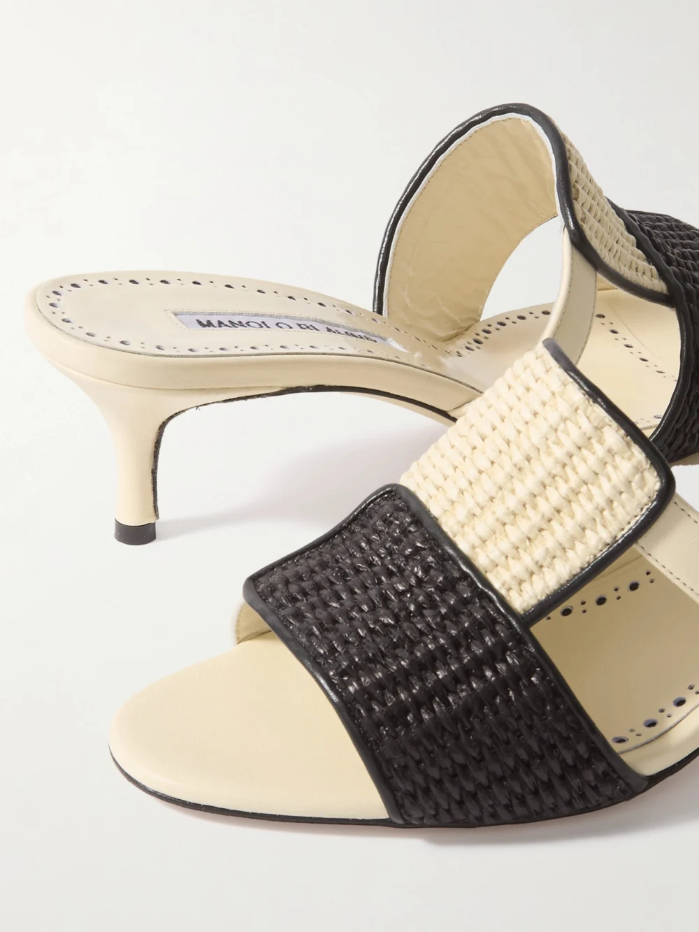 Close-up detail of the Manolo Blahnik Fabiolamu 50 Cutout Leather-trimmed Two-tone Raffia Mules