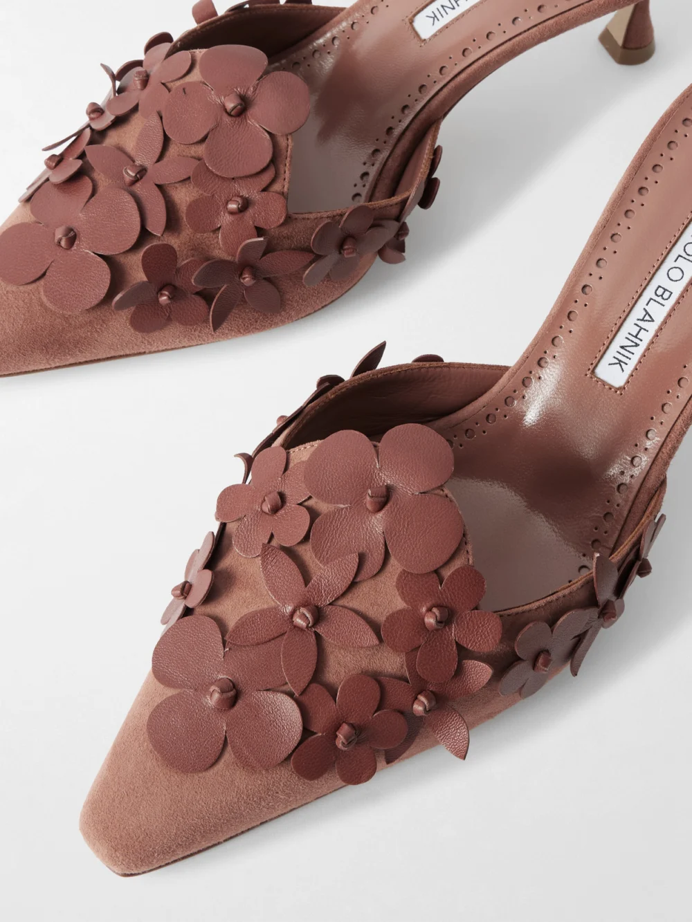 Close-up detail of the Manolo Blahnik Harnes 50 Appliquéd Suede Mules