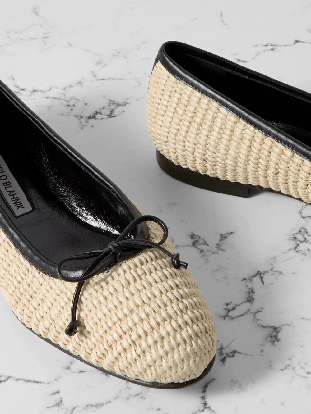 Close-up detail of the Manolo Blahnik Veralli Leather-trimmed Raffia Ballet Flats