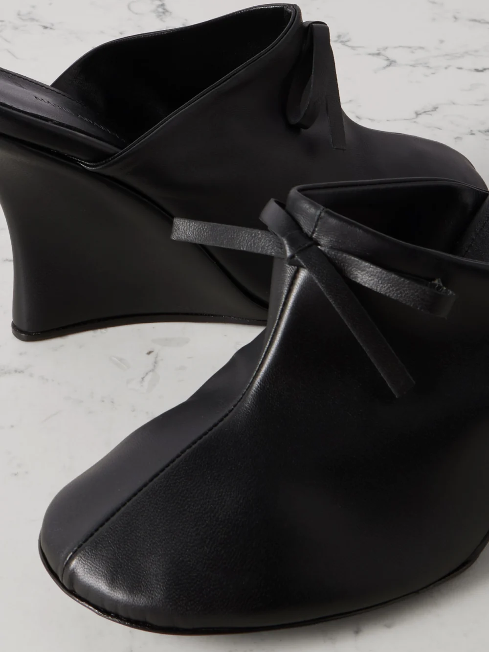 Close-up detail of the Marie Adam-Leenaerdt Bow-embellished Leather Wedge Mules