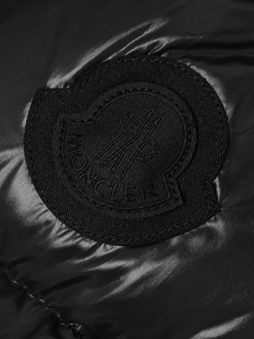 Close-up detail of the Moncler Appliquéd Quilted Padded Glossed-shell Down Jacket