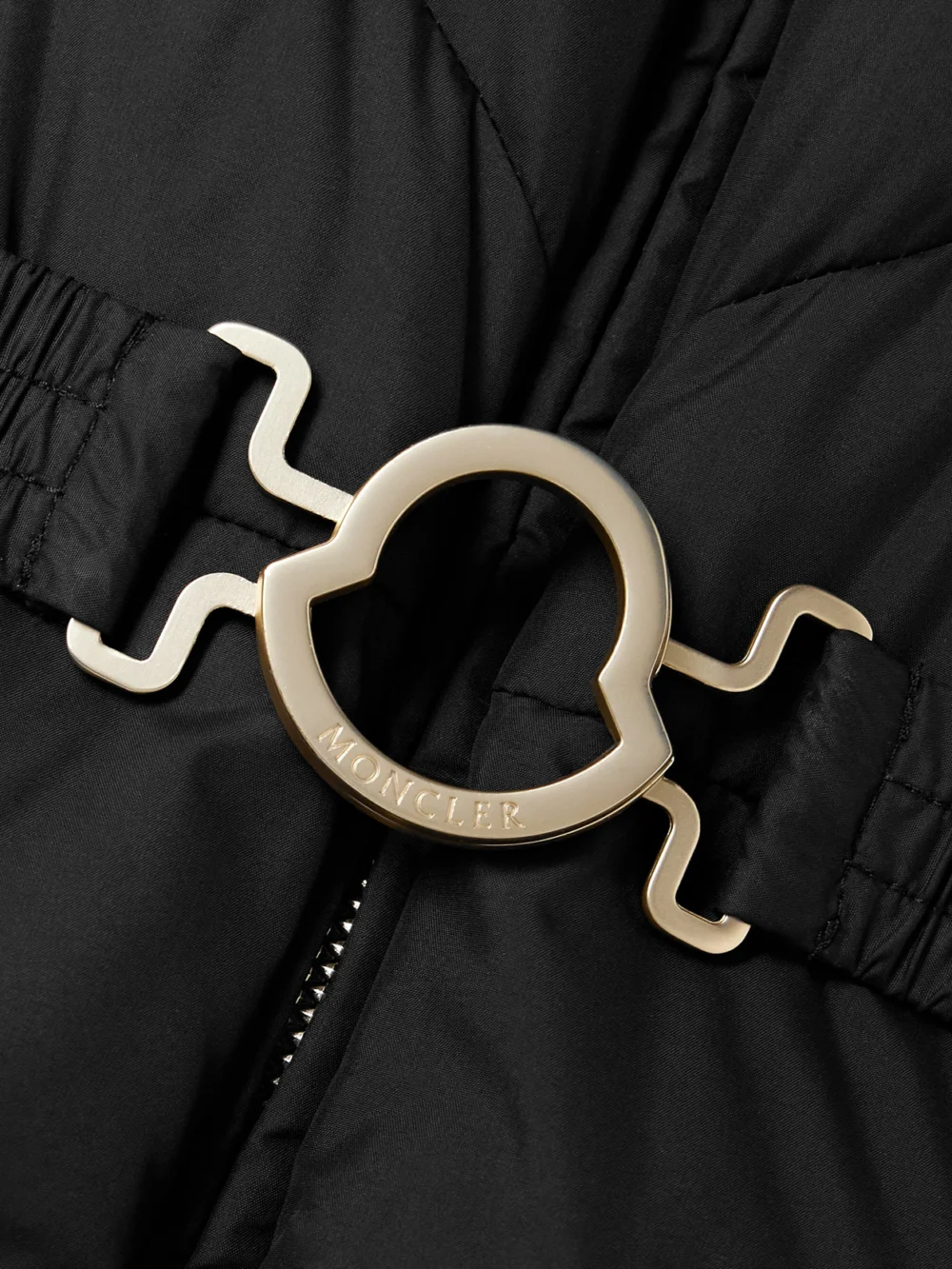 Close-up detail of the Moncler Brosse Belted Hooded Appliquéd Quilted Shell Down Jacket