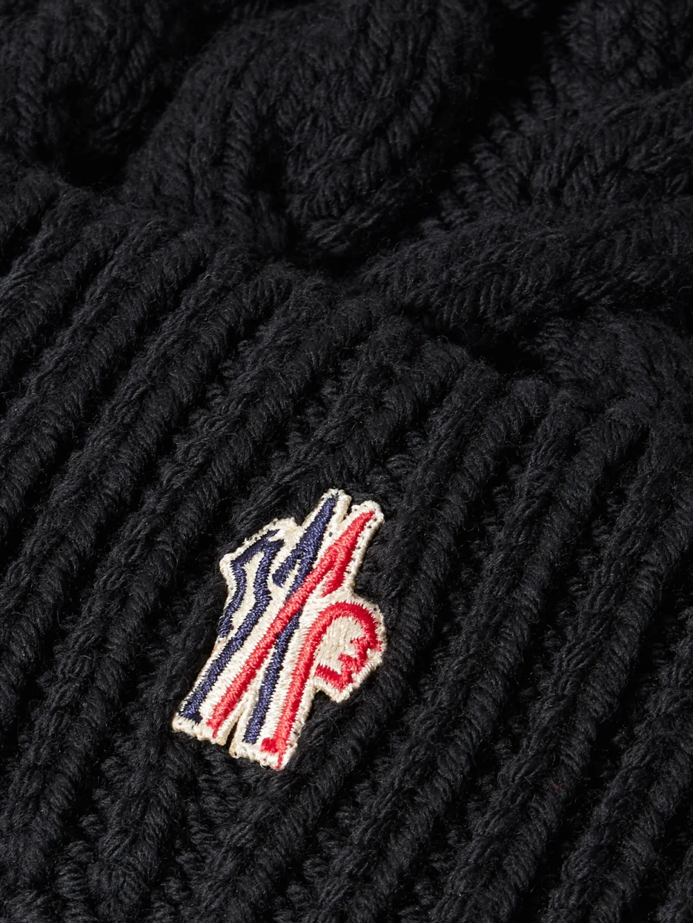 Close-up detail of the Moncler Grenoble Appliquéd Cable-knit Wool Beanie