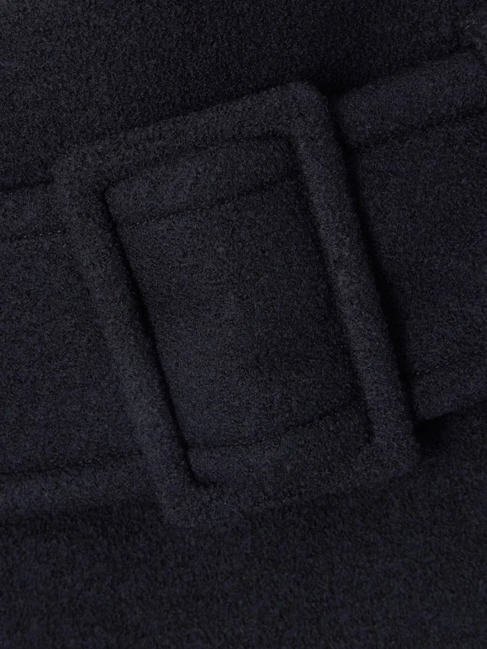 Close-up detail of the Patou Belted Wool Mini Skirt