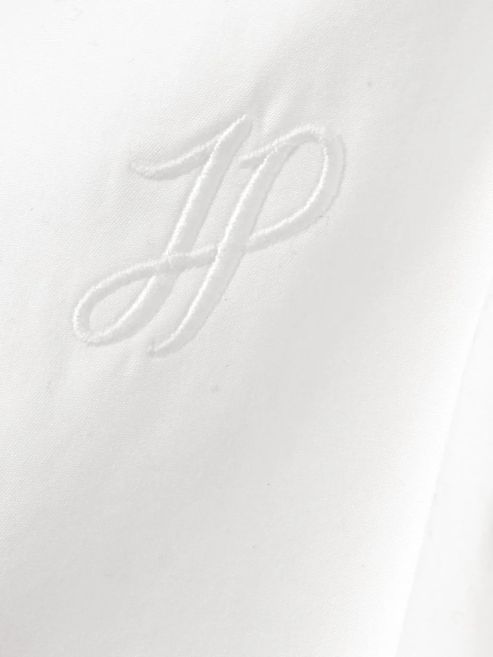 Close-up detail of the Patou Cropped Open-back Scalloped Cotton-poplin Top