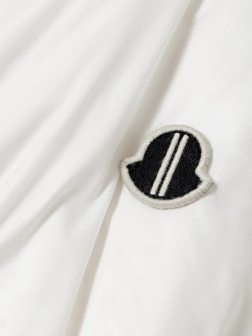 Close-up detail of the Rick Owens + Moncler Cyclopic Oversized Hooded Appliquéd Quilted Shell Down Jacket