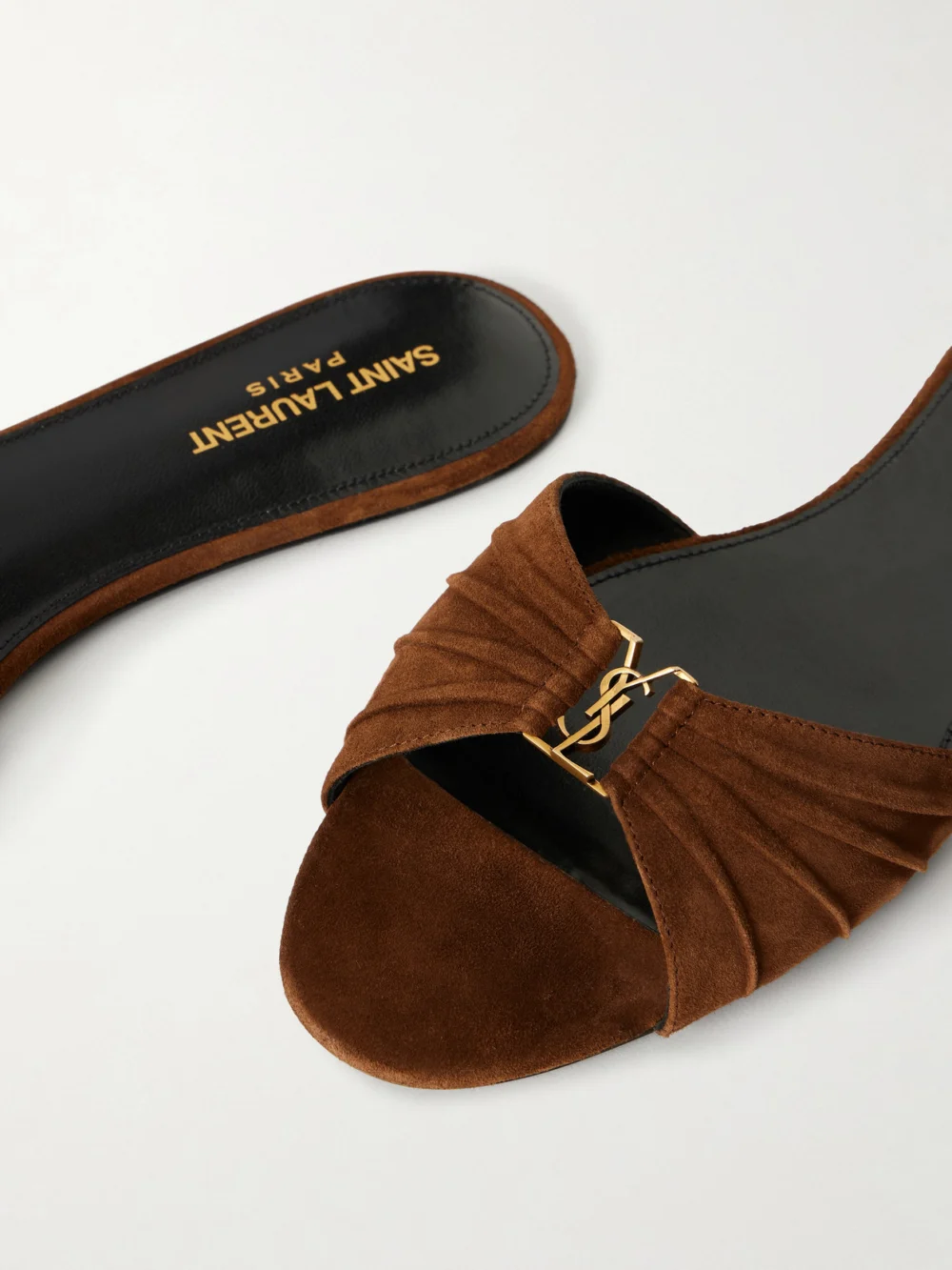 Close-up detail of the Saint Laurent Babylon Cassandre-embellished Suede Slides