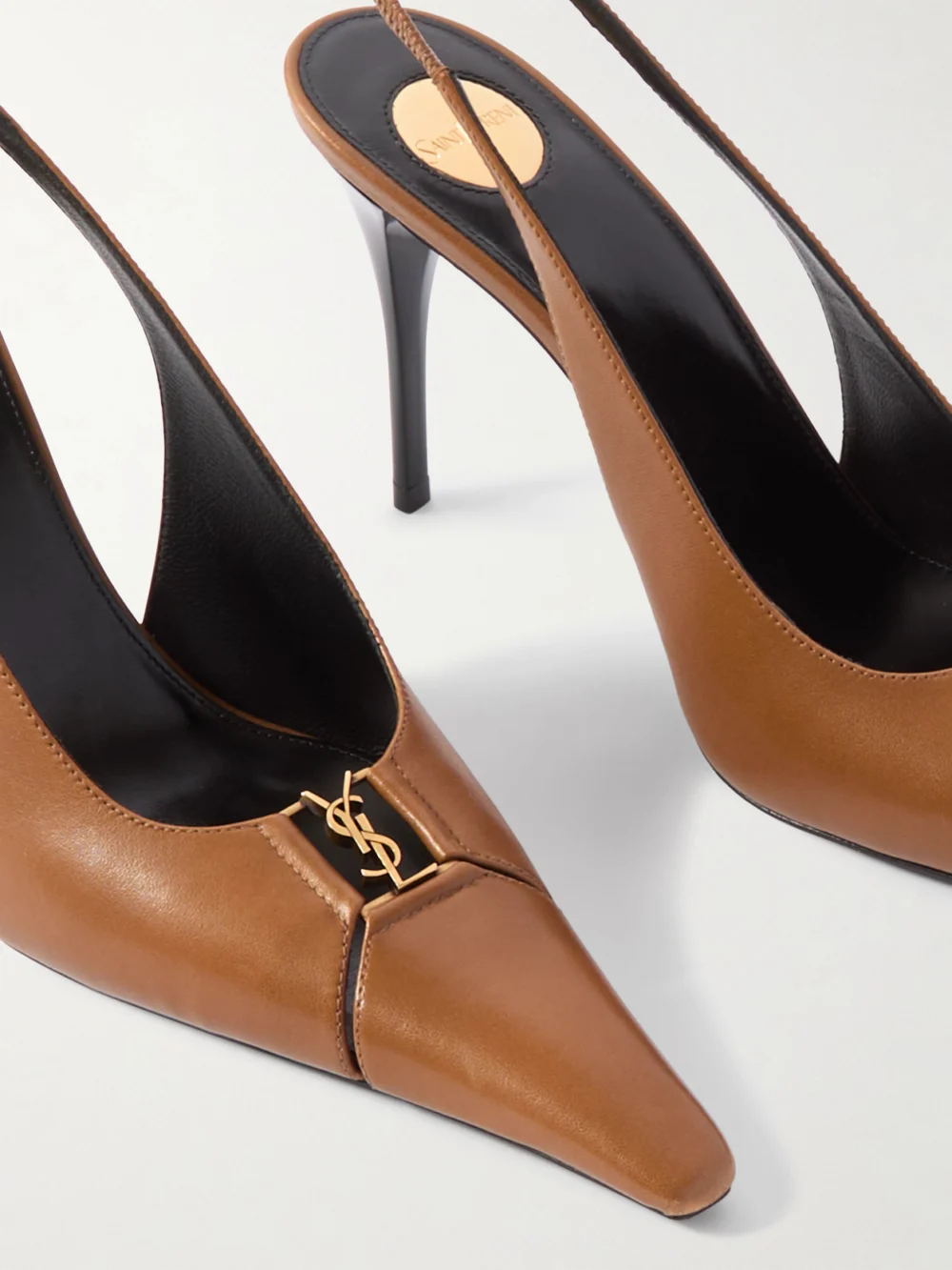 Close-up detail of the Saint Laurent Babylone Cassandre-embellished Cutout Patent-leather Slingback Pumps
