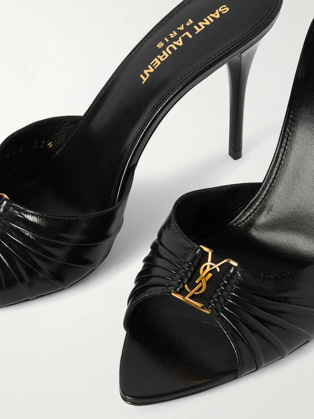 Close-up detail of the Saint Laurent Babylone Cassandre-embellished Gathered Glossed-leather Mules