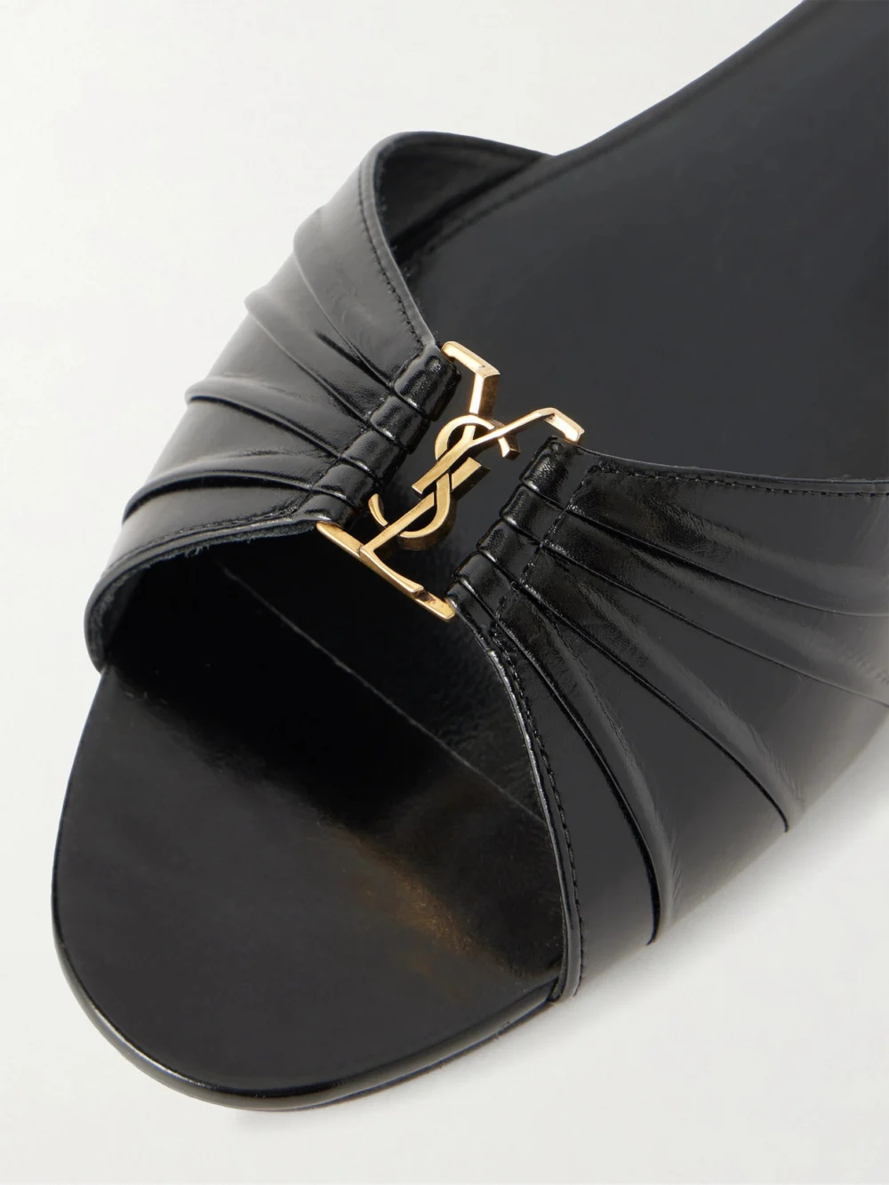 Close-up detail of the Saint Laurent Babylone Cassandre-embellished Gathered Glossed-leather Slides