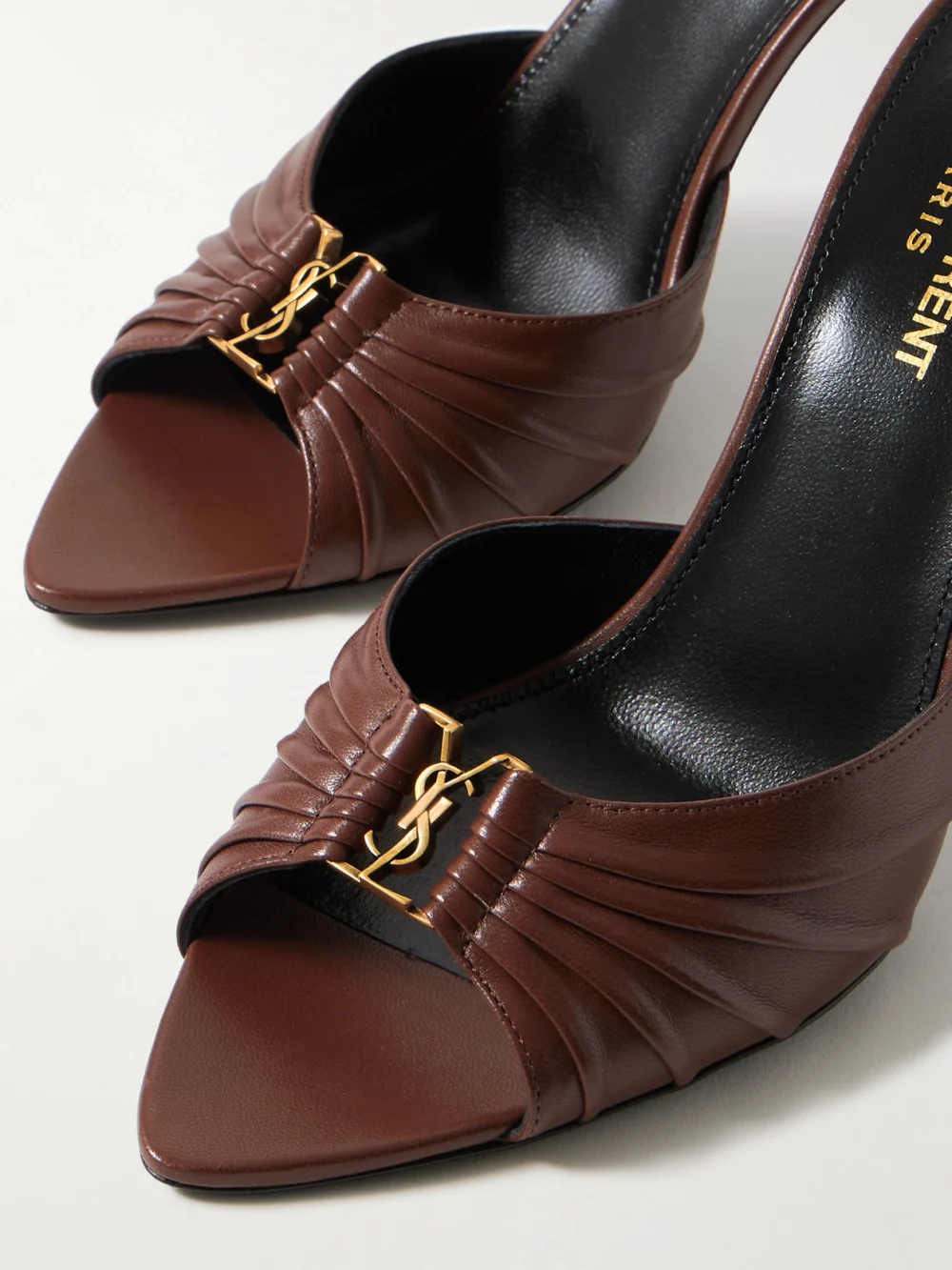 Close-up detail of the Saint Laurent Babylone Cassandre-embellished Gathered Leather Mules
