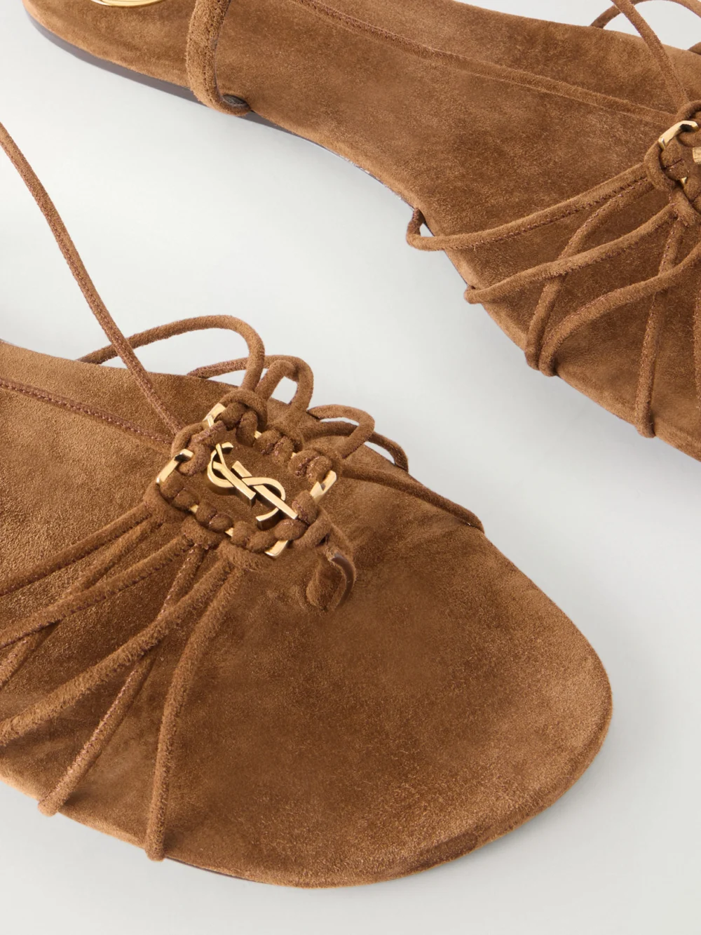 Close-up detail of the Saint Laurent Babylone Cassandre-embellished Lace-up Suede Sandals