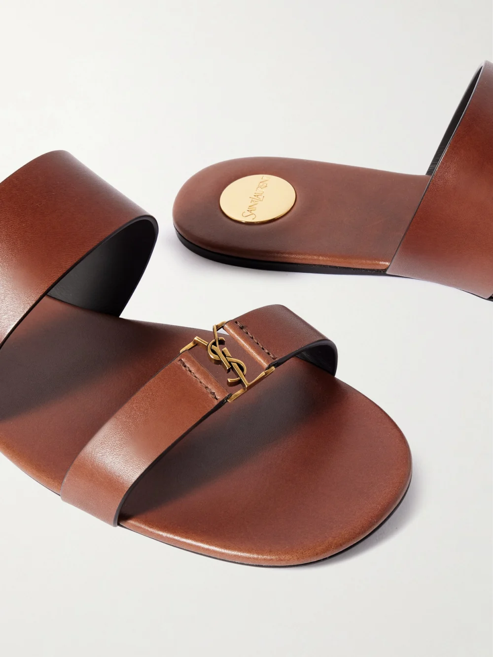 Close-up detail of the Saint Laurent Babylone Cassandre-embellished Leather Slides