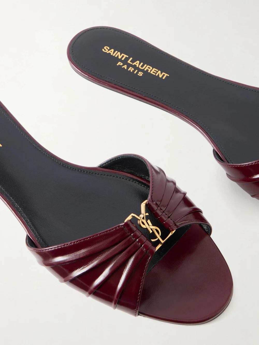 Close-up detail of the Saint Laurent Babylone Cassanre-embellished Gathered Glossed-leather Slides